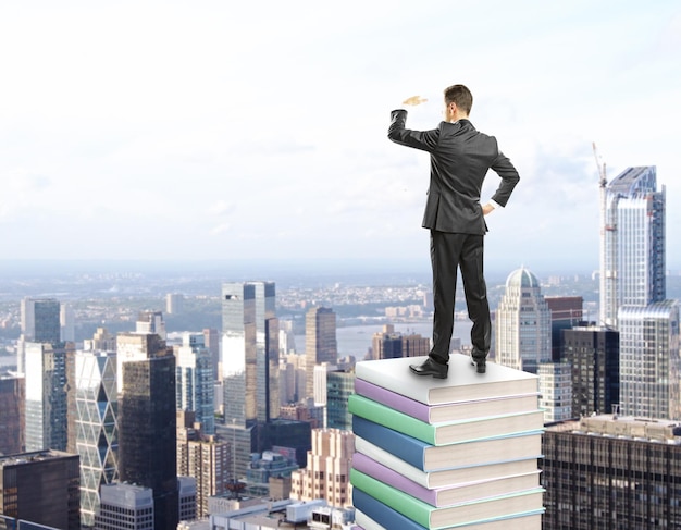 Businessman standing on stack of books