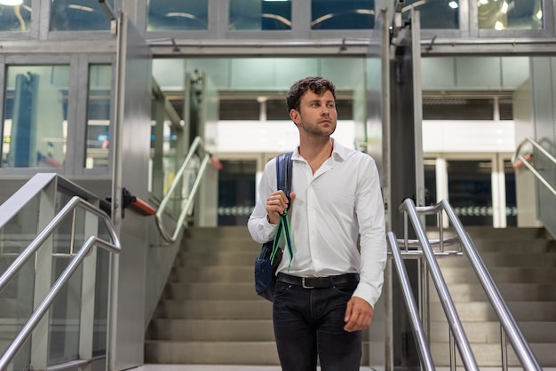 Uomo d'affari in piedi sui gradini in aeroporto