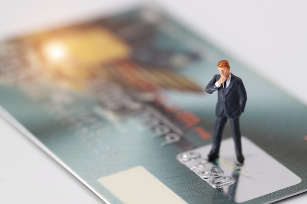 businessman standing and thinking on credit card as payment and purchase online solution 