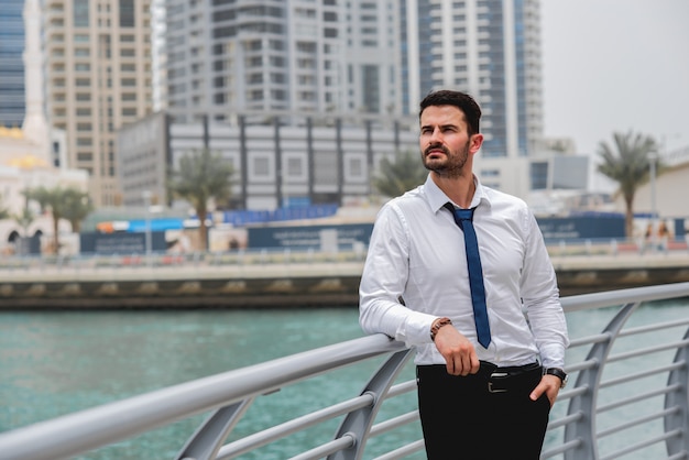 Businessman standing thinking near river.