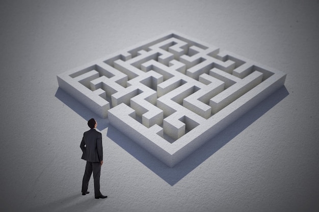 Businessman standing with hand on hip against maze puzzle