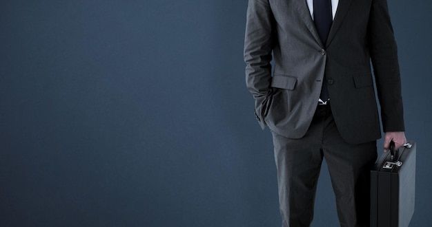 Businessman standing with his briefcase against grey background