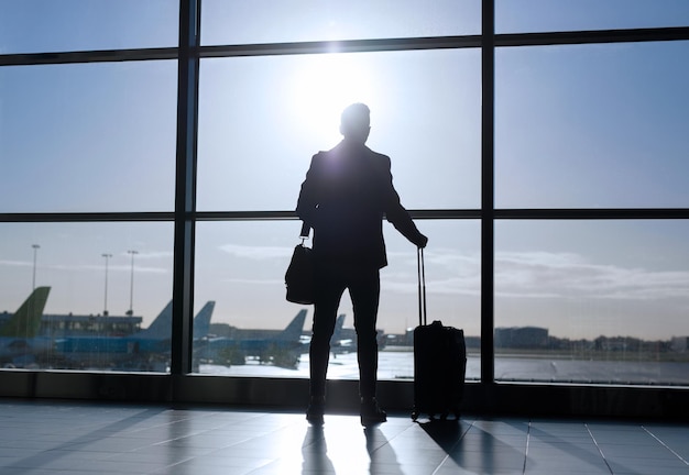 Businessman standing with suitcase in airport