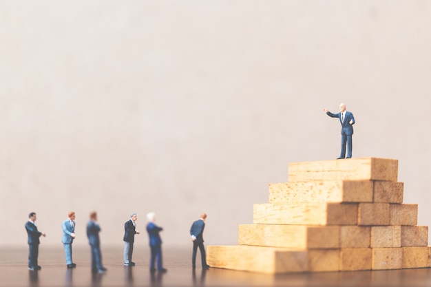 Businessman standing on wooden block 