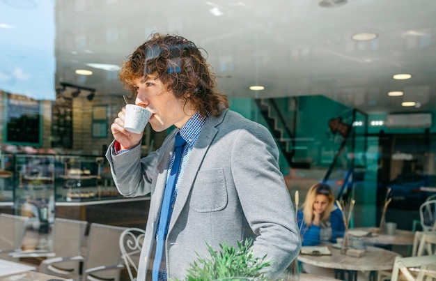 Businessman stirring coffee in the coffee shop