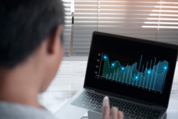 Businessman stock trading analyzing graph chart forex by using laptop computer