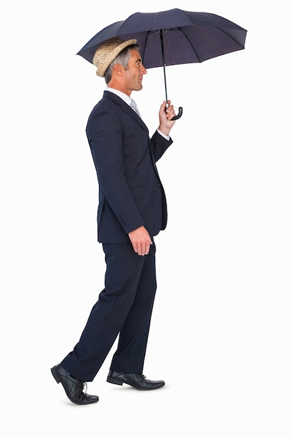 Businessman in straw hat under umbrella