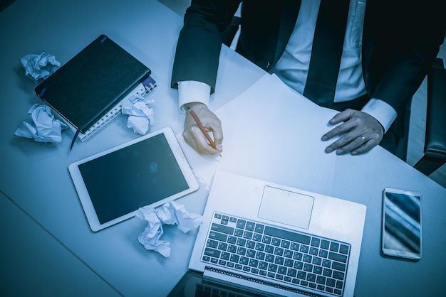 Businessman stress from hard work on the desk at office dark tone