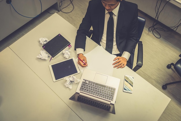 Photo businessman stress from hard work on the desk at office dark tone