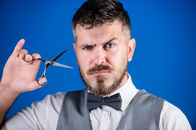 Photo businessman strict face hold scissors barber with beard and mustache hold steel scissors grooming beard create your style macho bearded barber hold scissors cut hair barbershop service concept