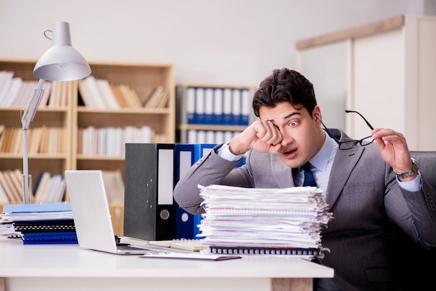 Businessman struggling with stacks of papers