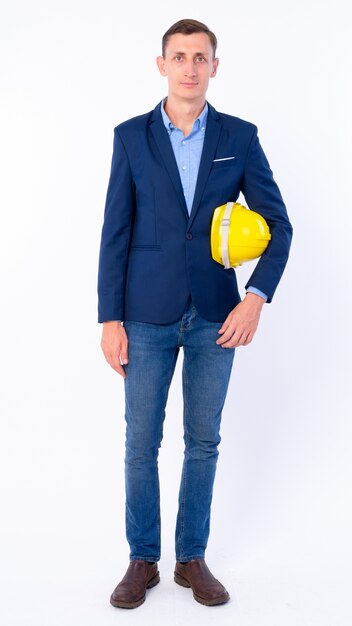  businessman in suit as engineer holding hardhat isolated against white wall