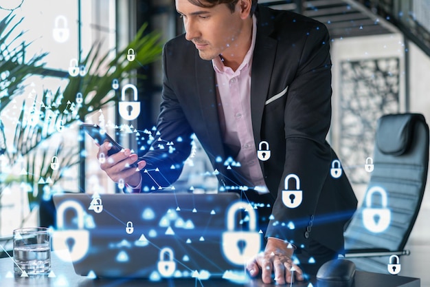 Businessman in suit checking cyber security using smart phone to protect clients confidential information IT hologram lock icons over modern panoramic office background