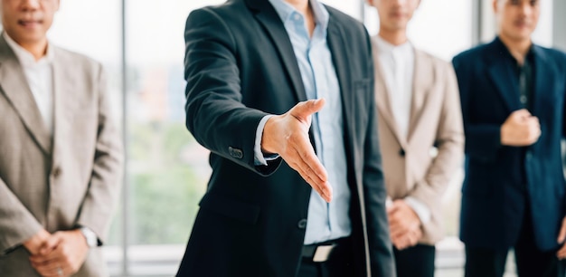 Businessman in suit extends his open palm in gesture of request and handshake symbolizing trust successful cooperation and teamwork in office setting It represents professionalism and confidence