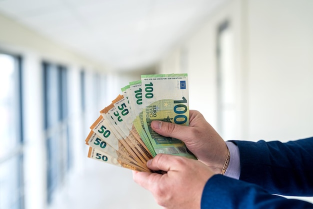 Businessman in suit giving euro money finance wage or bribe concept