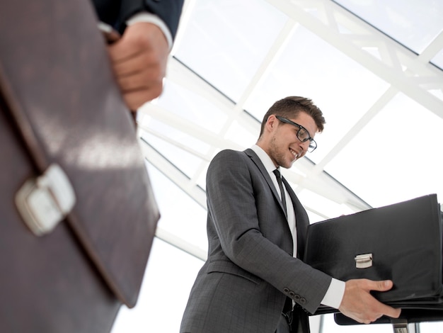 Businessman in suit holding briefcase with papers