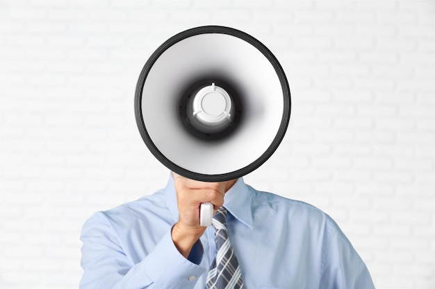 Businessman in suit holding megaphone on blurred background