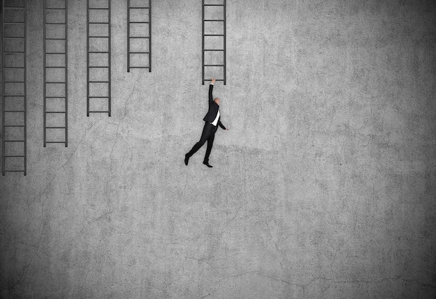 Businessman in suit hung on ladder