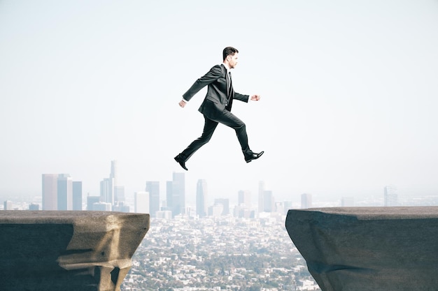 Businessman in suit jumping on mountain