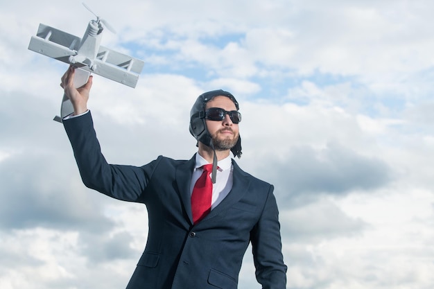 Businessman in suit and pilot hat launch plane toy achievement