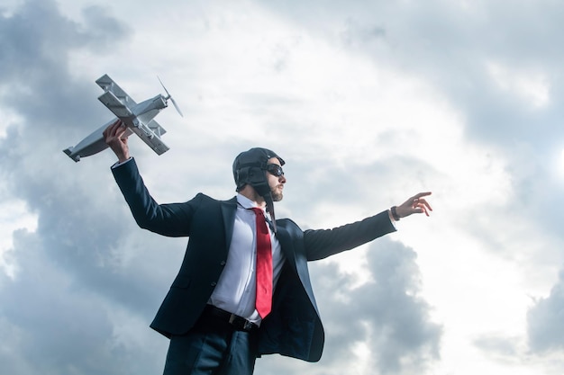 Businessman in suit and pilot hat launch plane toy metaphor