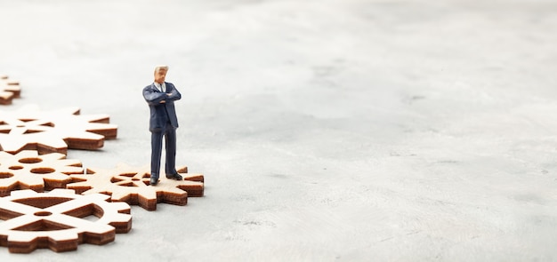 Businessman in suit shaking hands on gears as a symbol of business processes in the company.