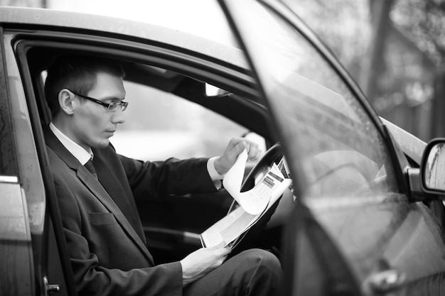 Businessman in a suit on the street in a car