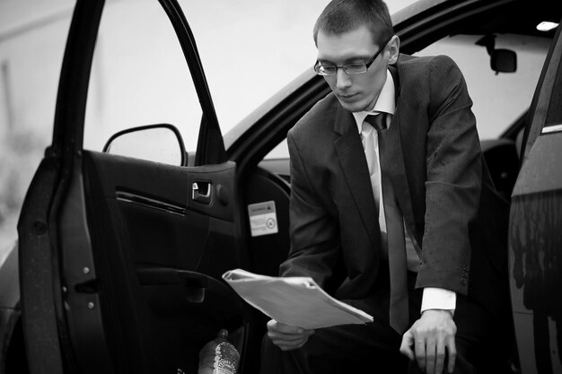 Businessman in a suit on the street in a car