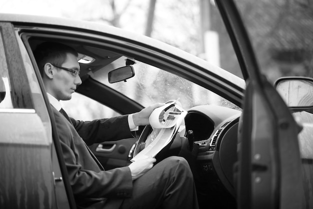 Businessman in a suit on the street in a car