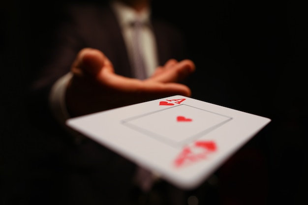 Businessman in suit throws his hand playing card ace