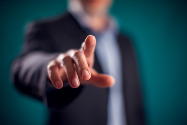 Photo businessman in suit touching virtual button or pointing at something