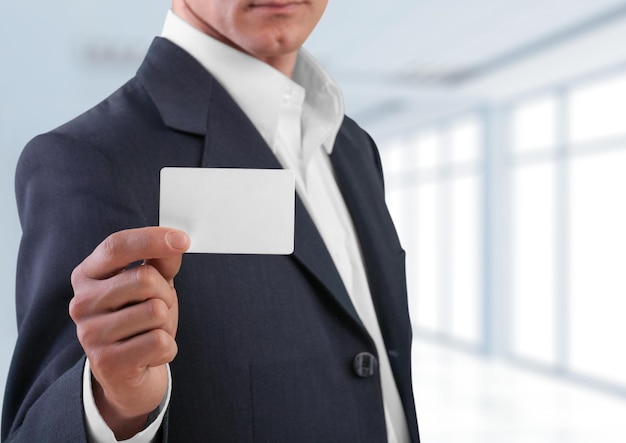 Photo businessman in suit with card on office background