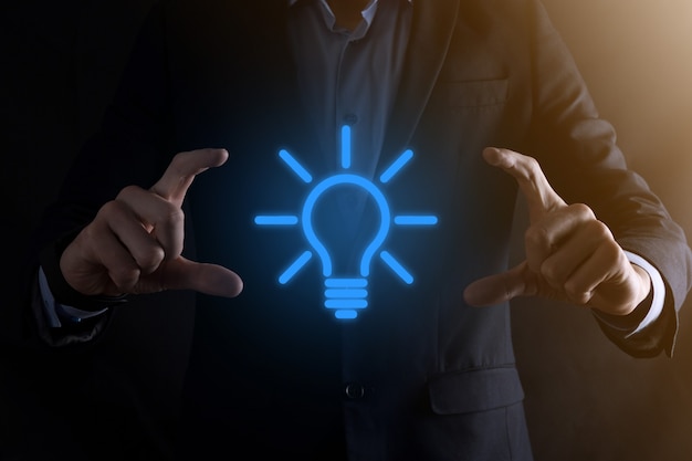 Photo businessman in a suit with a light bulb in his hands.