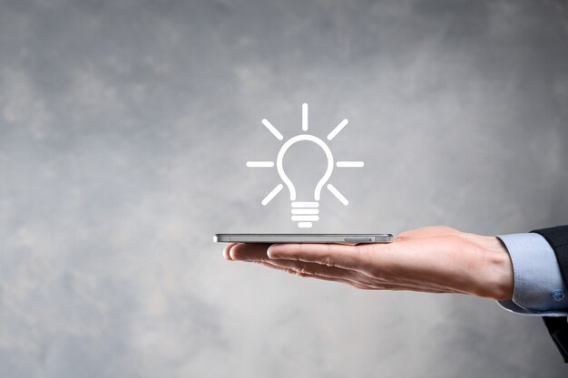 Businessman in a suit with a light bulb in his hands