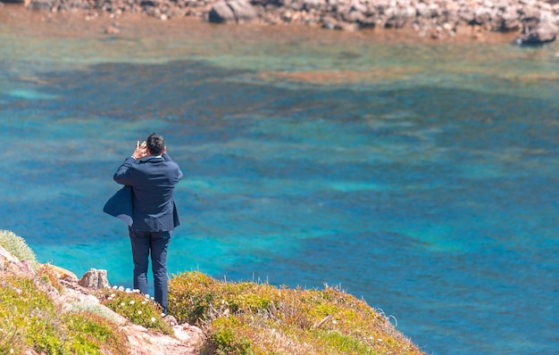 Businessman takes photos with smartphone on the coast