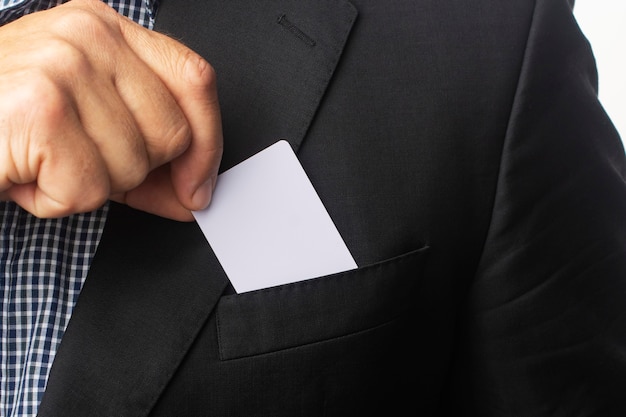 businessman takes a white business card out of his jacket pocket.