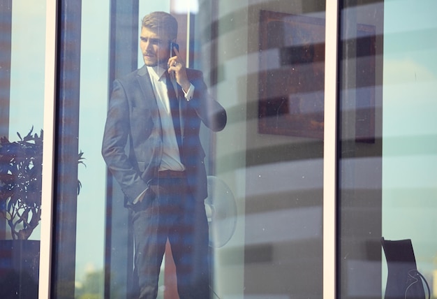 Businessman talk to cellphone and look out of window