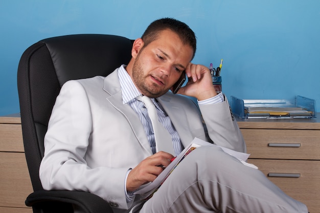 Businessman talking to mobile in office