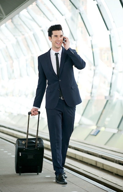 Businessman talking on mobile phone at metro station