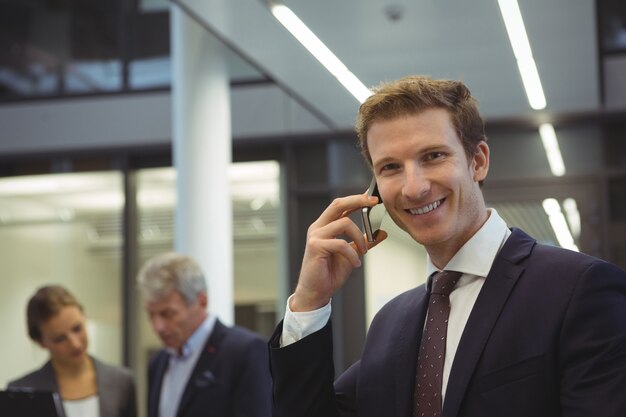 Businessman talking on mobile phone at office