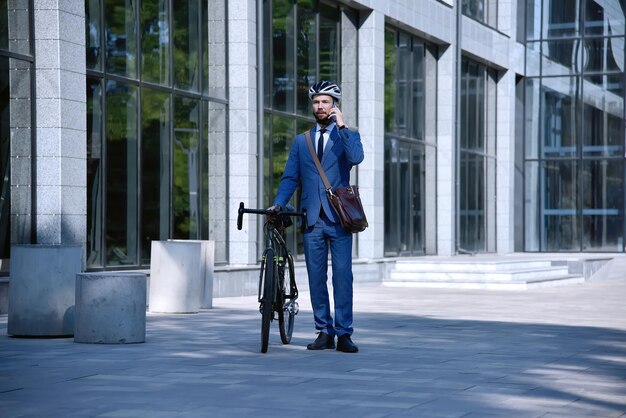 Businessman talking on mobile phone with bike