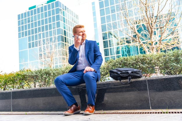 Photo businessman talking to the mobile sitting outside in the city