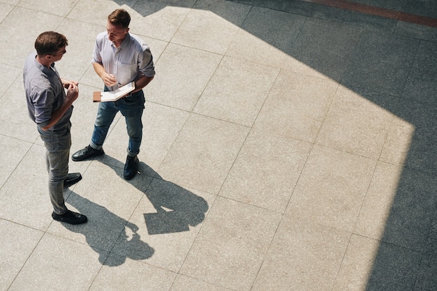 Businessman talking outdoors with coworker