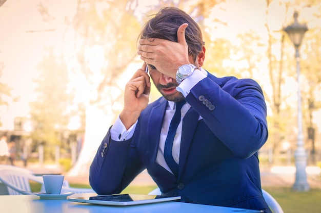 Foto uomo d'affari che parla al telefono all'aperto