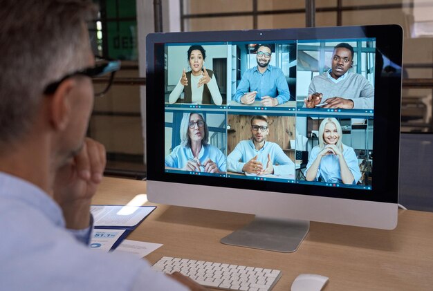 Photo businessman talking with team leading virtual meeting on computer over shoulder