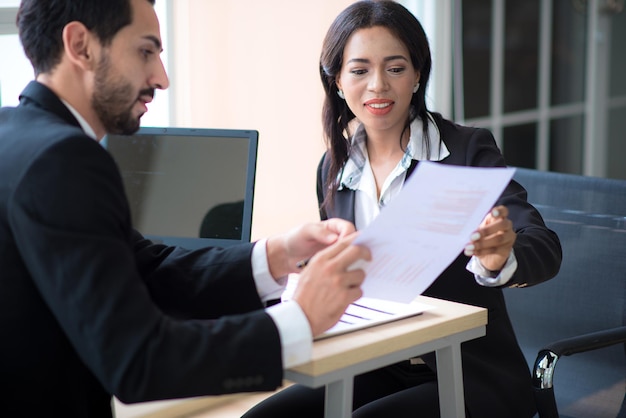 Businessman talks to an African businesswoman or partner about company's earnings or stock growth