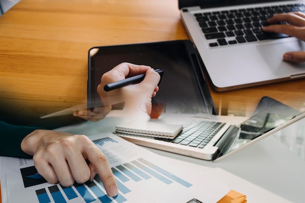 Businessman and team analyzing financial statement Finance task with smart phone and laptop and tablet Wealth management concept