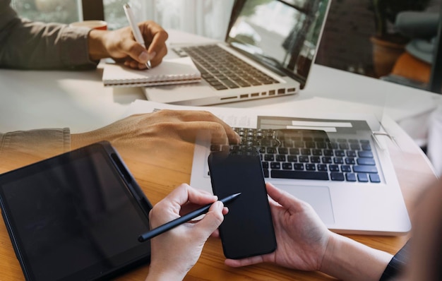 Businessman and team analyzing financial statement Finance task with smart phone and laptop and tablet Wealth management concept