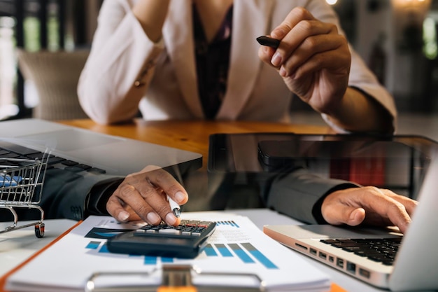 Businessman and team analyzing financial statement Finance task with smart phone and laptop and tablet Wealth management concept