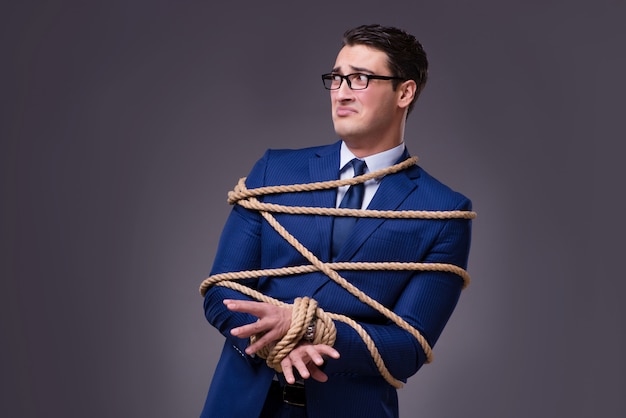 Businessman tied up with rope